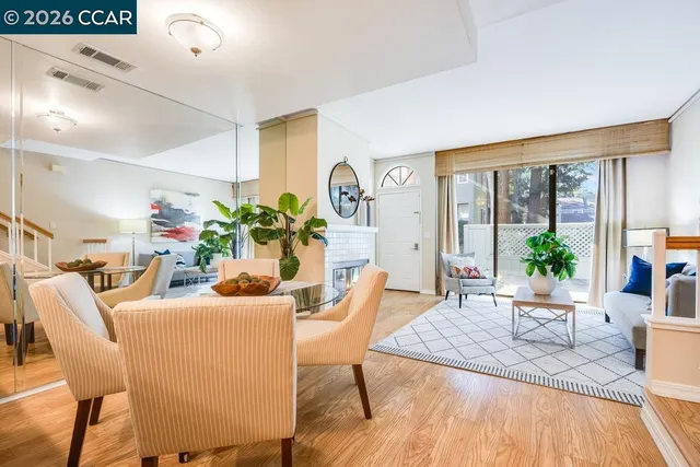 a dining room with furniture potted plants and wooden floor