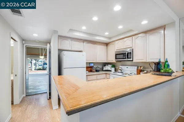 a kitchen with sink refrigerator and microwave