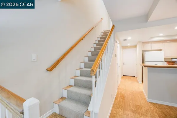 a view of entryway and kitchen with wooden floor
