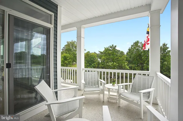 a living room with furniture kitchen view and a wooden floor