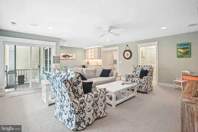 a living room with furniture large window and a ceiling fan