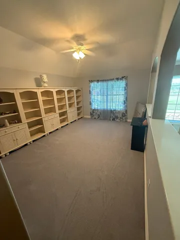 a view of a hallway with wooden floor and windows