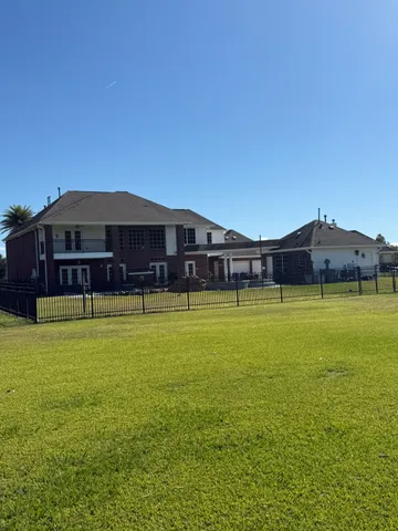 a large pool that has lawn chairs under an umbrella