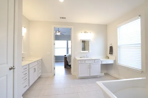 a bathroom with a tub sink and mirror