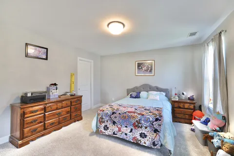 a bedroom with a bed and a dresser in it
