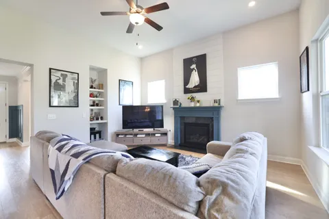 a living room with furniture a fireplace and a flat screen tv