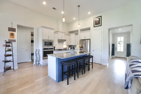 a kitchen with stainless steel appliances kitchen island granite countertop a refrigerator and a stove top oven