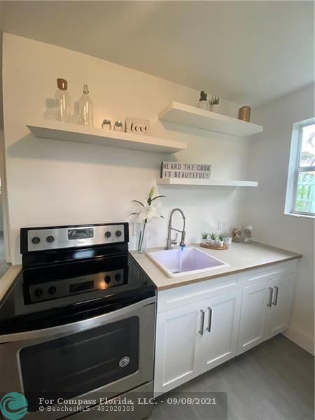 a utility room with sink and wooden floor