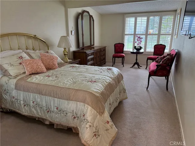 a bedroom with bed and large windows