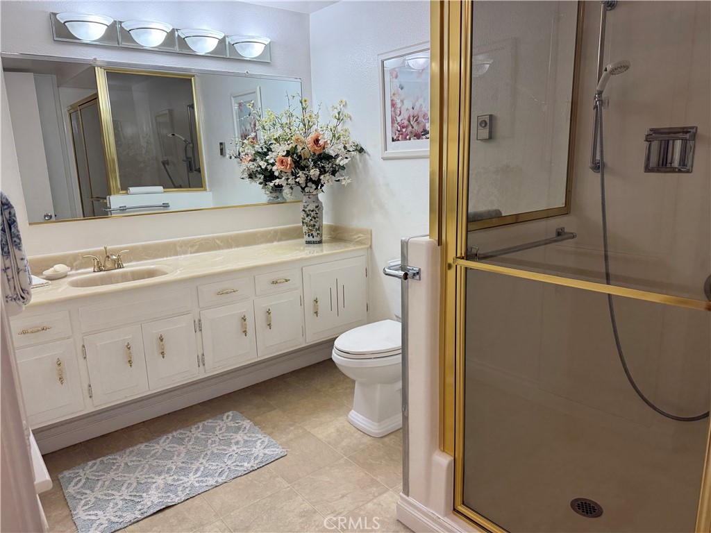 1441 Homewood Road Seal Beach, CA 90740 - Photo 20 of 25 a bathroom with a granite countertop sink a toilet a mirror and shower