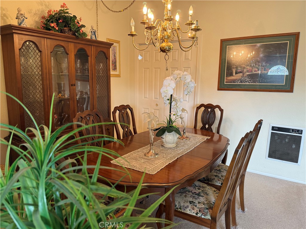 1441 Homewood Road Seal Beach, CA 90740 - Photo 10 of 25 a dining room with wooden floor a chandelier a wooden table and chairs