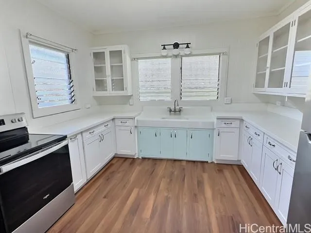 a kitchen with a sink a window and cabinets