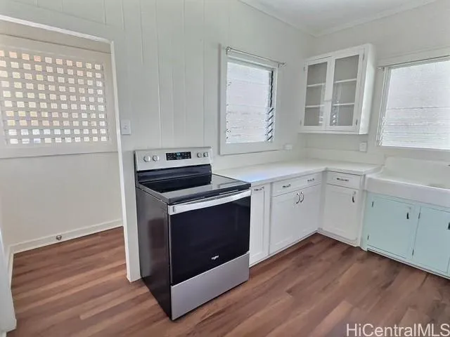 a view of a kitchen with wooden floor and electronic appliances