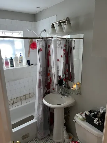 a bathroom with a sink and mirror with bathtub