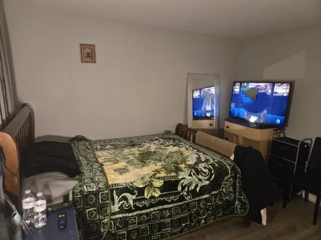 a bed sitting in a bedroom next to a window with tv