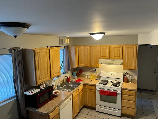 a kitchen with stainless steel appliances kitchen island granite countertop a sink stove and refrigerator