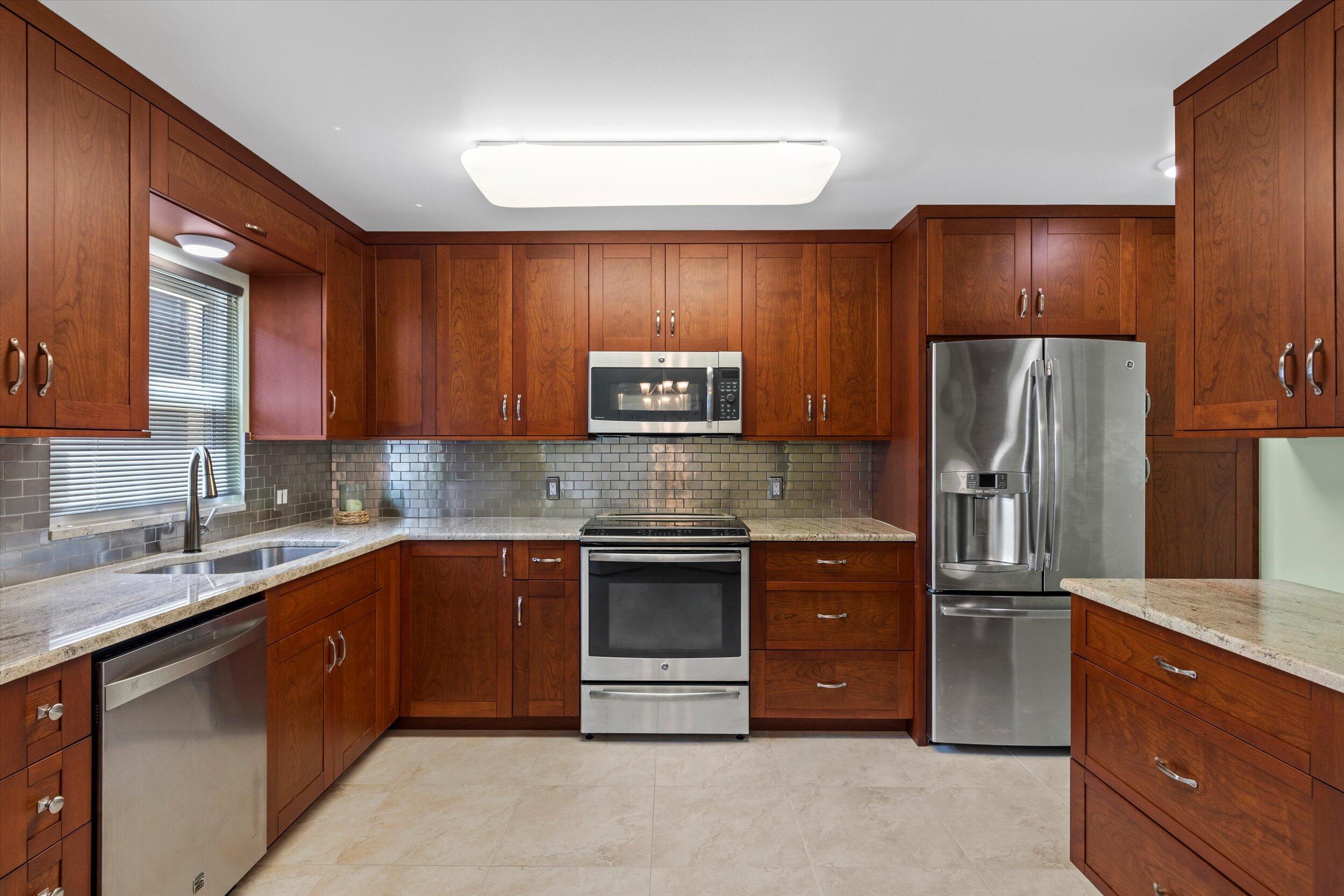 1616 Atlantic Boulevard, Unit 13 Key West, FL 33040 - Photo 12 of 38 a kitchen with stainless steel appliances granite countertop a refrigerator and a sink
