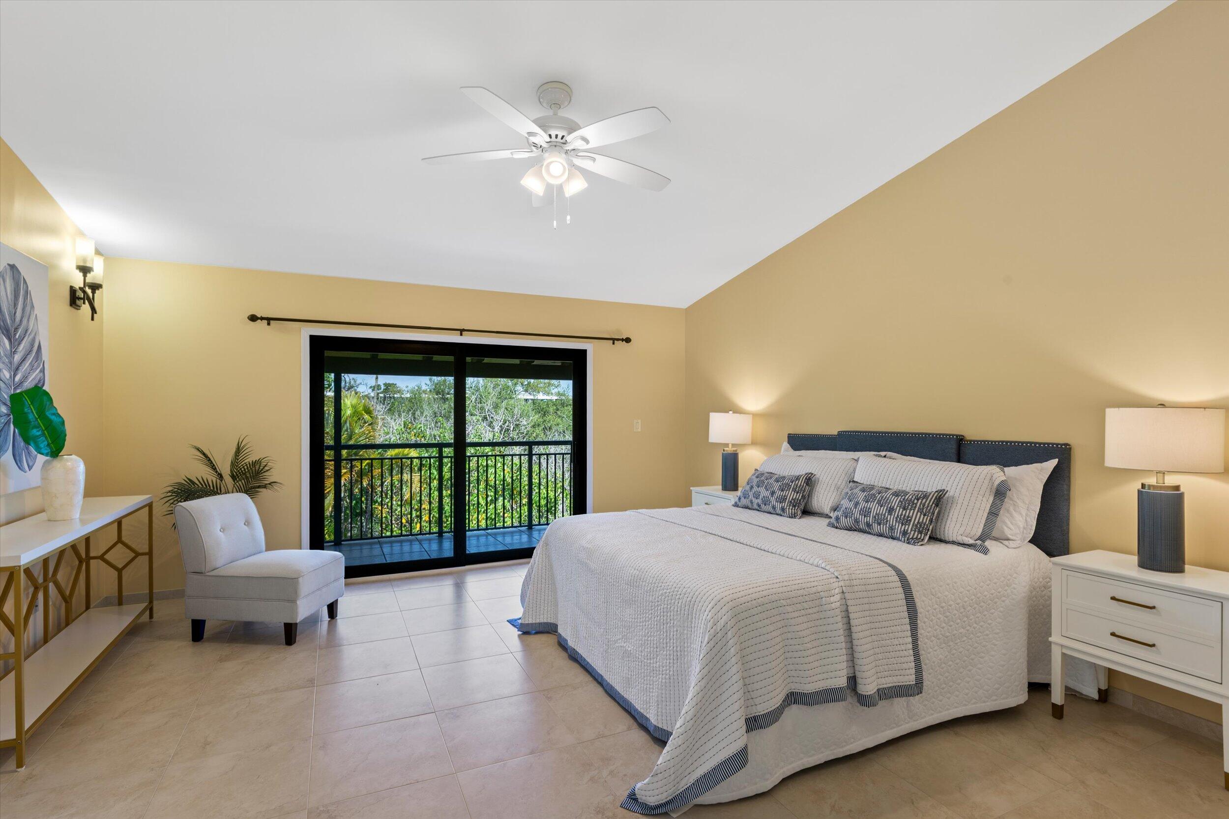 1616 Atlantic Boulevard, Unit 13 Key West, FL 33040 - Photo 14 of 38 a bedroom with a bed and a chandelier