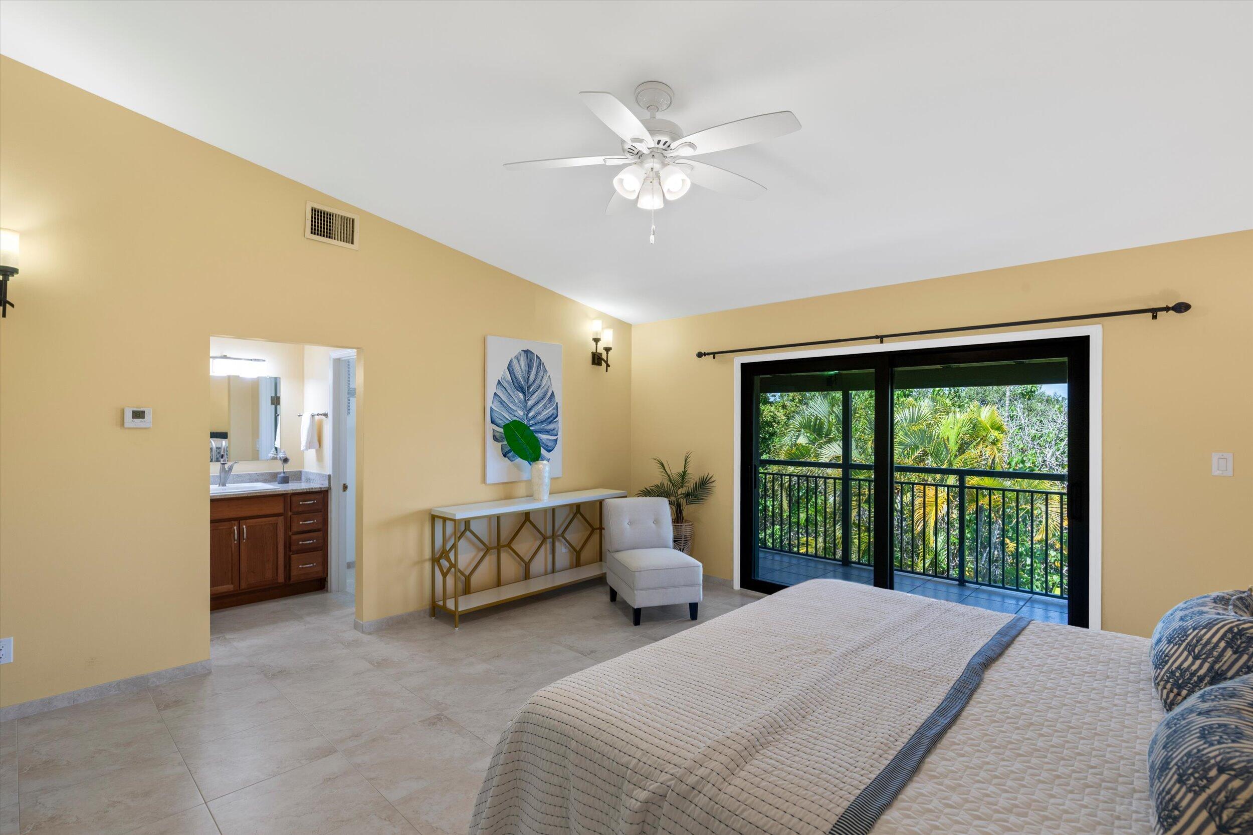 1616 Atlantic Boulevard, Unit 13 Key West, FL 33040 - Photo 15 of 38 a bedroom with a large bed and a chandelier