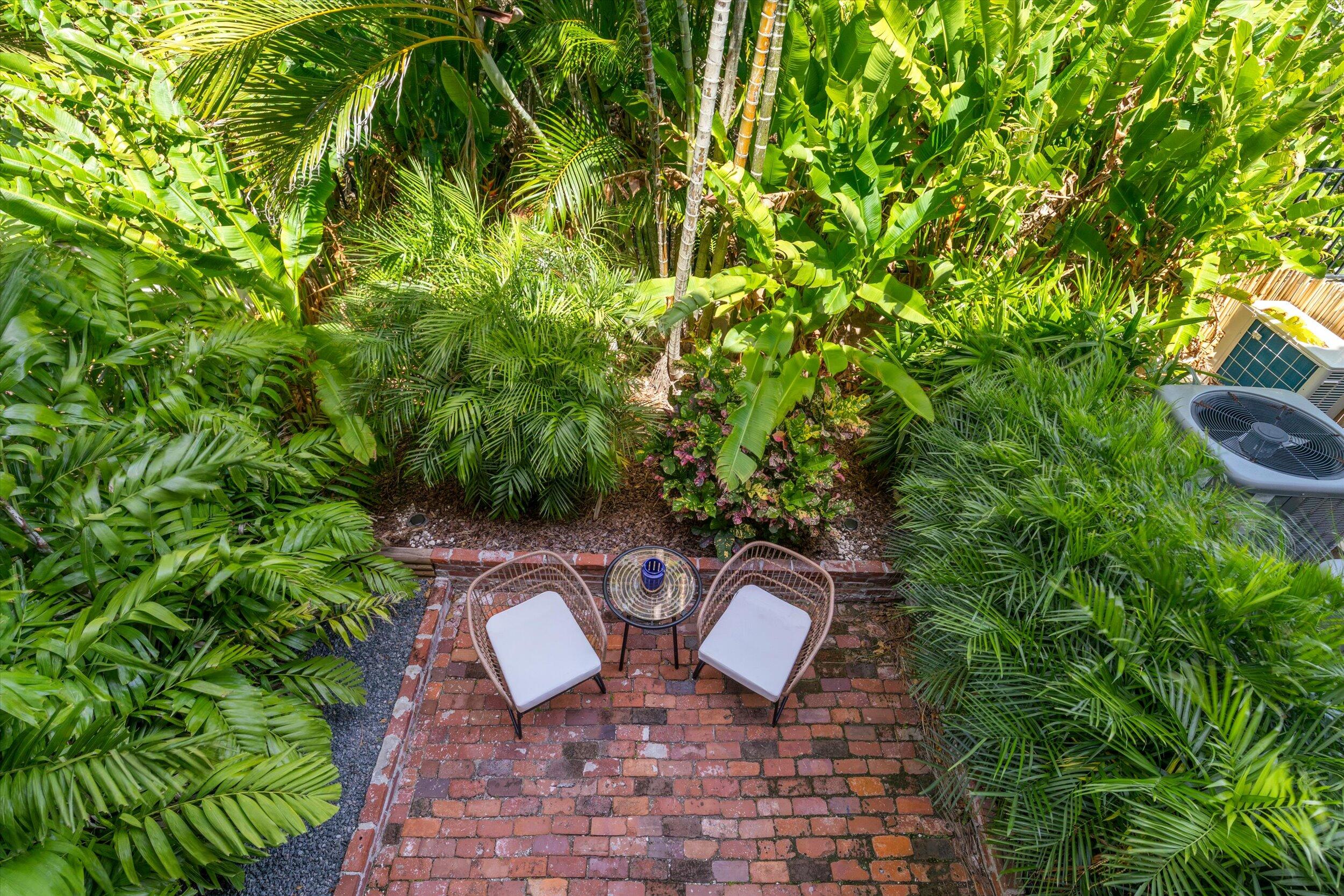 1616 Atlantic Boulevard, Unit 13 Key West, FL 33040 - Photo 9 of 38 a couple of potted plants sitting in middle of a garden