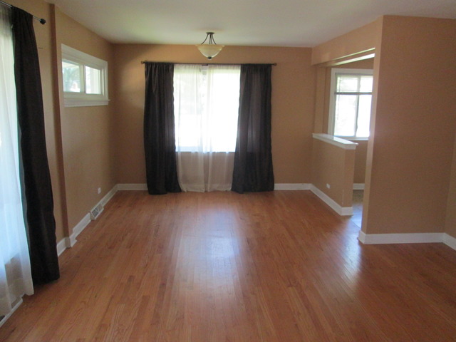 642 Wesley Drive Park Ridge, IL 60068 - Photo 2 of 11 an empty room with wooden floor and windows