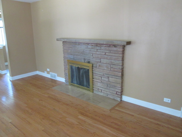 642 Wesley Drive Park Ridge, IL 60068 - Photo 3 of 11 an empty room with wooden floor and fireplace