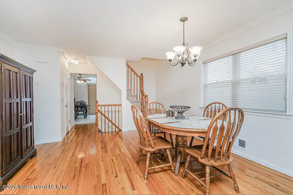 a dining room with furniture a chandelier and wooden floor