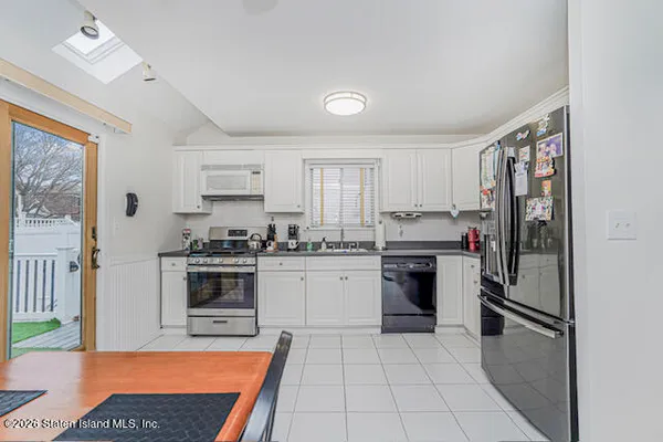 a kitchen with granite countertop a refrigerator stove top oven and sink