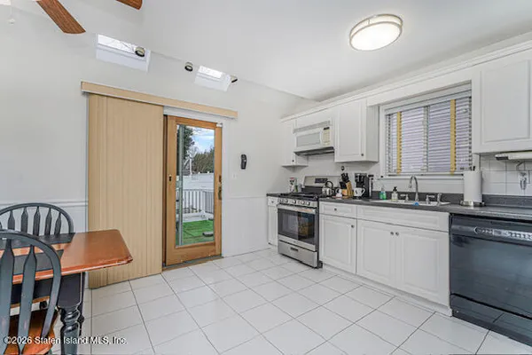 a kitchen with granite countertop a stove a sink and a refrigerator