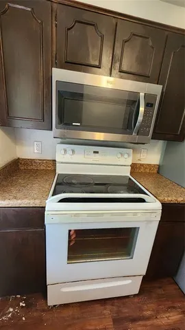 a room with granite countertop cabinets and wooden floor