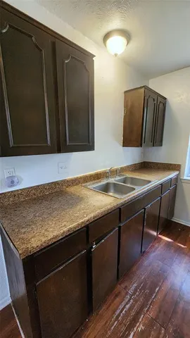 a view of a kitchen with wooden floor electronic appliances and window
