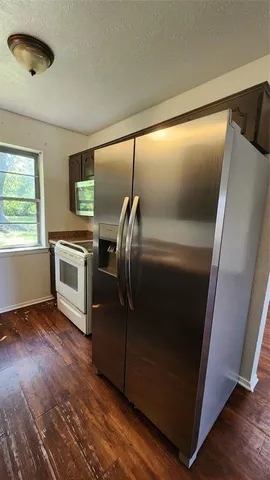 an empty room with a chandelier fan and windows