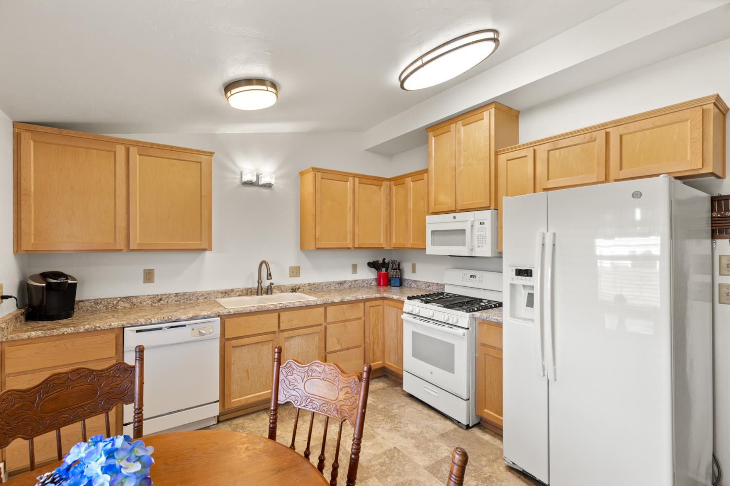 490 Hazel Street Gridley, CA 95948 - Photo 9 of 28 a kitchen with a sink a refrigerator a stove a dining table and chairs