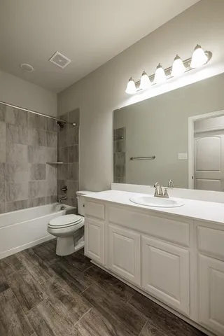 an empty room with a chandelier fan and windows