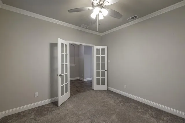 an empty room with closet and a ceiling fan