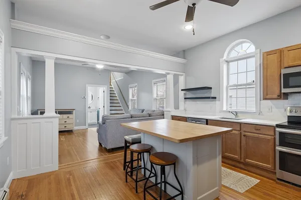 a open kitchen with stainless steel appliances granite countertop a sink dishwasher and a stove with wooden floor