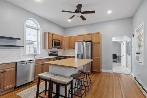 a kitchen with stainless steel appliances a table chairs refrigerator and microwave