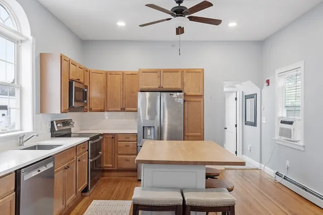 a kitchen with a table chairs refrigerator and microwave
