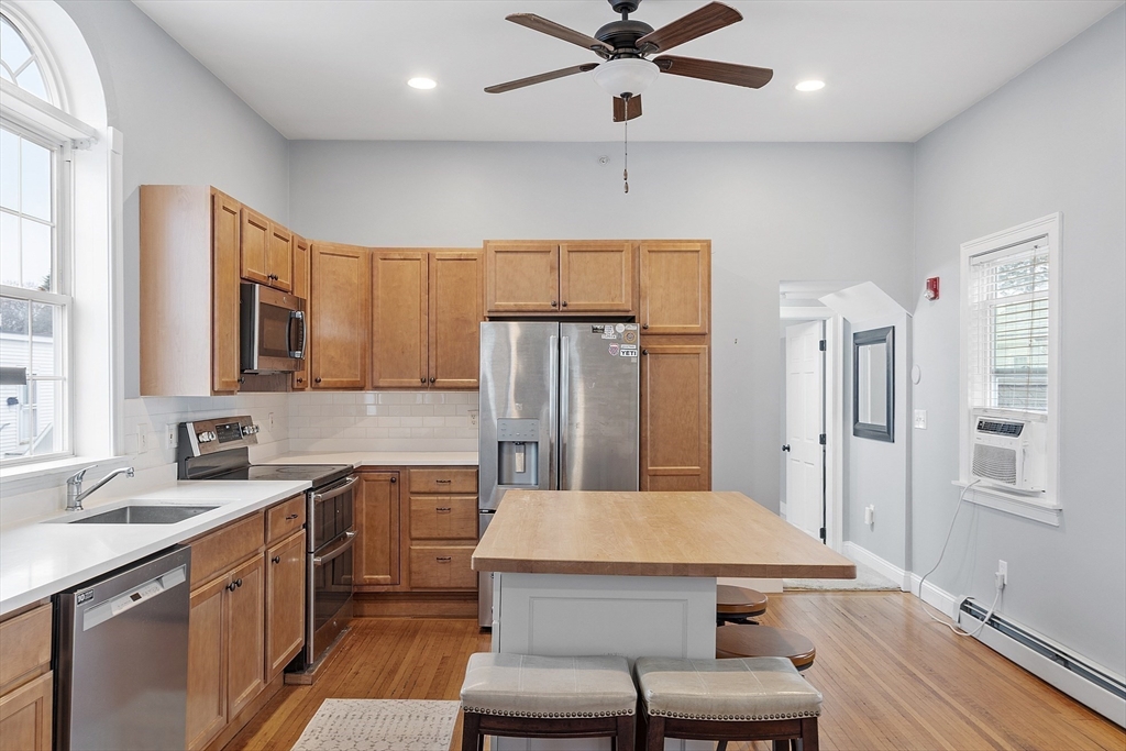 35 High Street, Unit 3D Danvers, MA 01923 - Photo 4 of 21 a kitchen with a table chairs refrigerator and microwave