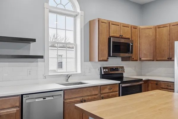 a kitchen with stainless steel appliances a stove sink microwave and cabinets