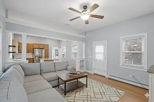 a living room with furniture a two couches and a dining table with wooden floor
