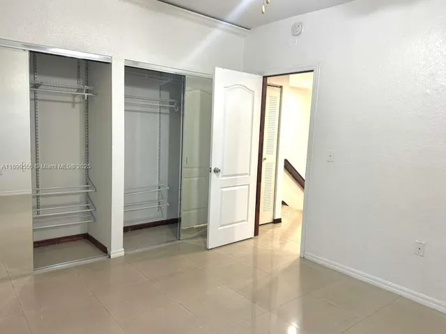 an empty room with a bench and a window