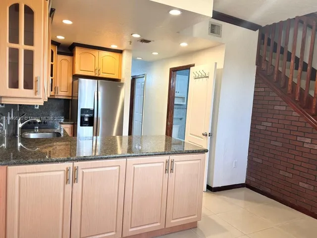 a kitchen with stainless steel appliances granite countertop a refrigerator and a sink