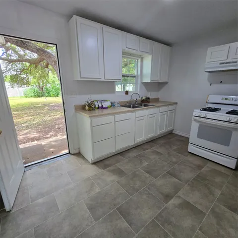 a kitchen with a stove a sink and a refrigerator