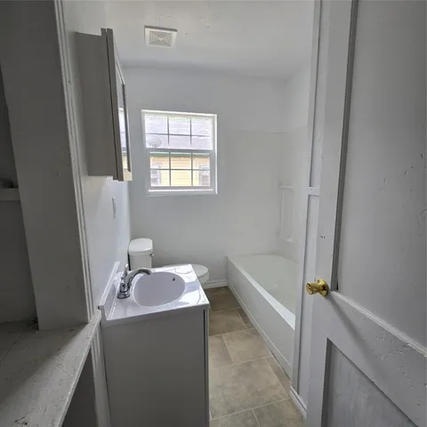 a bathroom with a tub sink and mirror