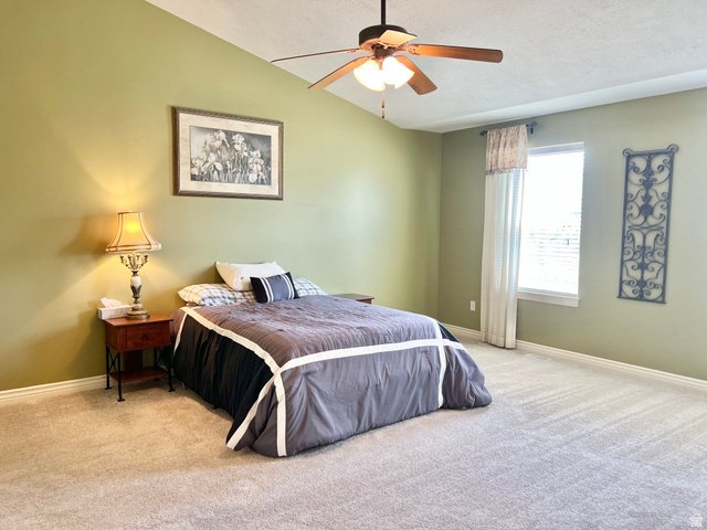 369 Culross Circle Tooele, UT 84074 - Photo 23 of 54 Spacious room featuring vaulted ceilings, a ceiling fan, light-colored carpet flooring, a window with blinds, and light green walls
