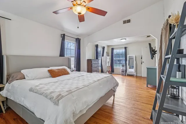 a bedroom with a large bed a flat tv screen and dresser