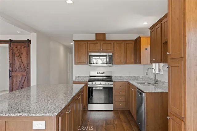 a kitchen with stainless steel appliances granite countertop a sink stove and cabinets