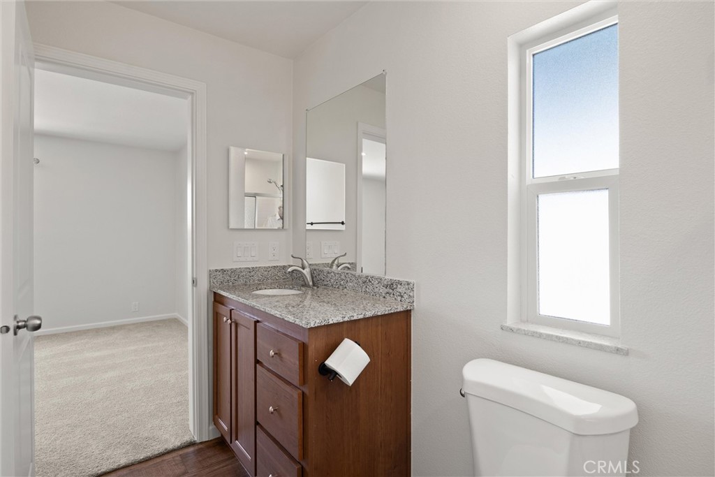 1575 La Grand View Road Paradise, CA 95969 - Photo 21 of 38 a bathroom with a granite countertop toilet a sink and a mirror