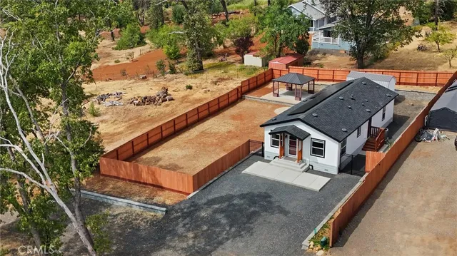 an aerial view of house with yard and mountain view in back